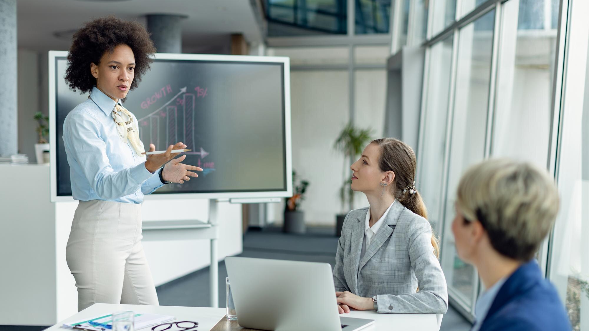 African american businesswoman giving a presentation to female colleagues in the office