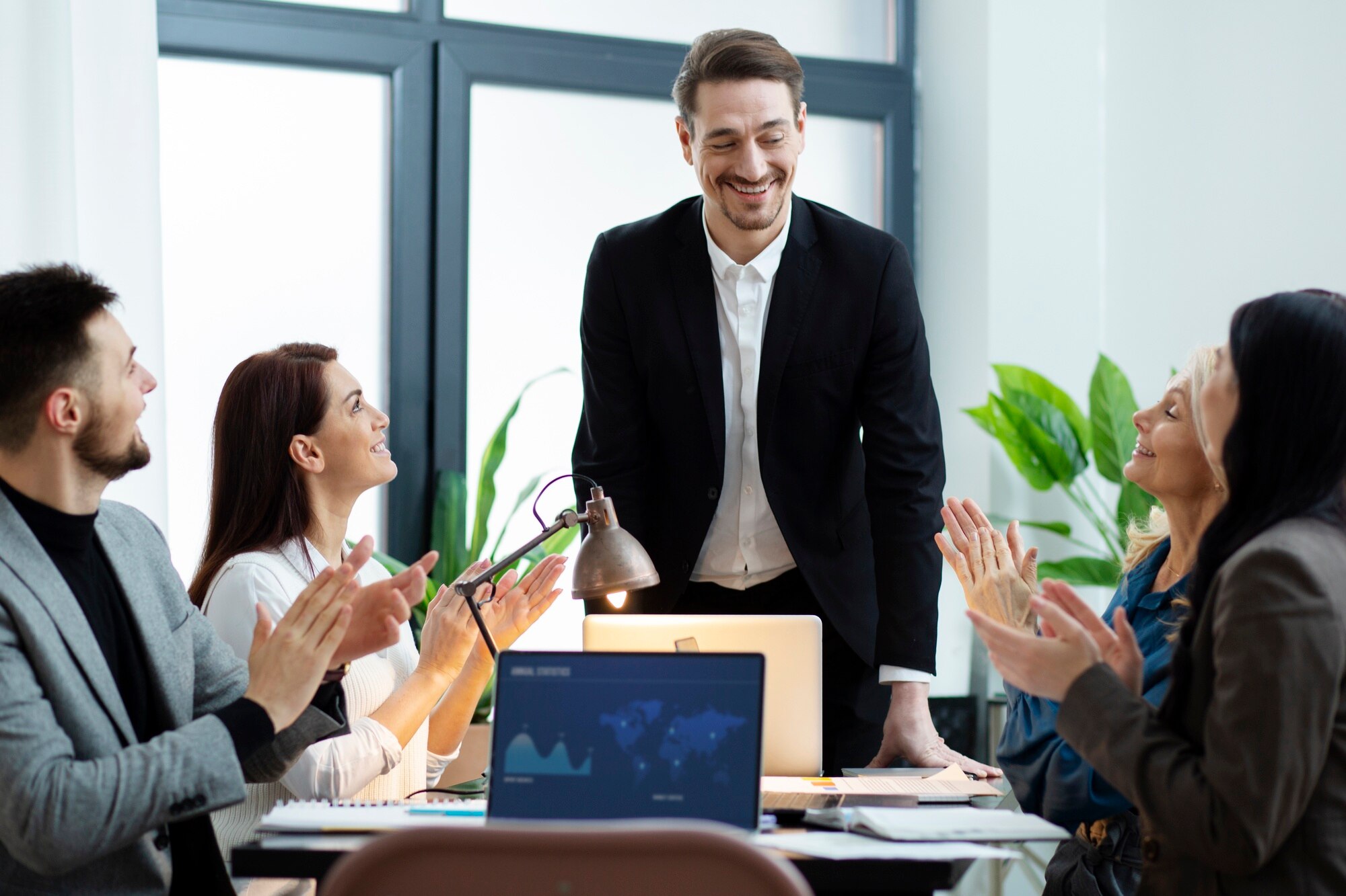 Team members applauding their team leader during a meeting